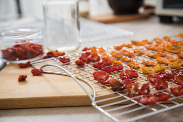 Getrocknete Cherrytomaten gelb und rot auf Dörrautomat Edelstahl Gitter und in Schraubglas für...