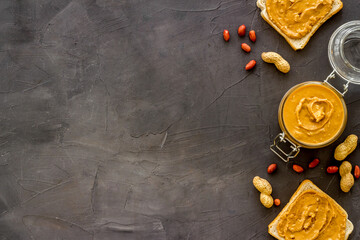 Bowl of peanut butter with nuts on kitchen table. Overhead view