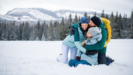 Family with small daughter hugging outdoors in winter nature, Tatra mountains Slovakia.