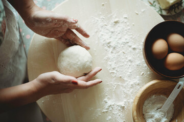 Hand skills in food preparation.Lady molding dough with hands.Messy table with baking ingredients.Flour.Baker profession.Culinary art class for adults.Pastry and bakery.Eggs in bowl.