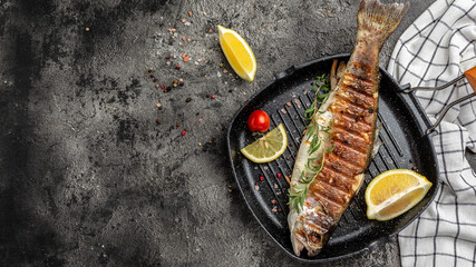 Grilled trout fish on the grill pan with lemon. banner, menu, recipe place for text, top view