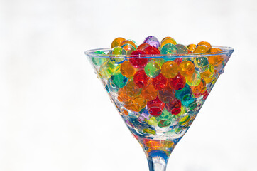 glass on a white background and sunlight, full of semitransparent multi-colored beads, selective focus and artistic blur.