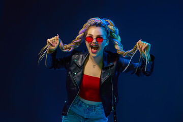 young woman with dreadlocks in red sunglasses dancing