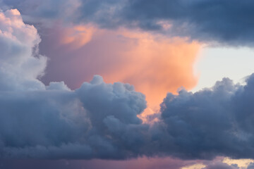 Beautiful colored dramatic stormy cumulus clouds on sky at sunset. Close-up view. Background texture