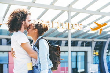 Happy interracial couple meeting at the airport. Husband kissing wife and embracing her at...