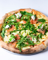 Pizza with mozzarella, salmon slices, fresh arugula. Isolated on white background. Italian cuisine concept