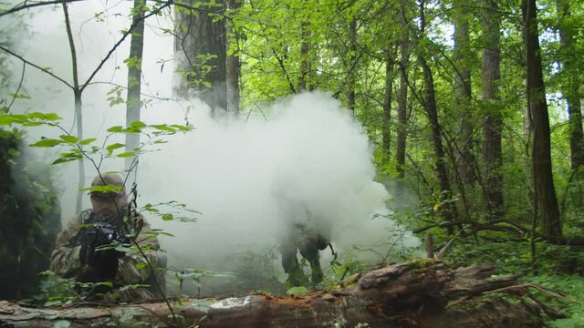 Military female soldier in camouflage with assault rifle overcoming obstacles in dense forest, while machine gunner and sniper covering relocation of counter-terrorist group outdoors