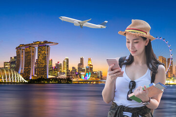 Beautiful asian woman smiling and booking an air ticket to travel to Singapore.