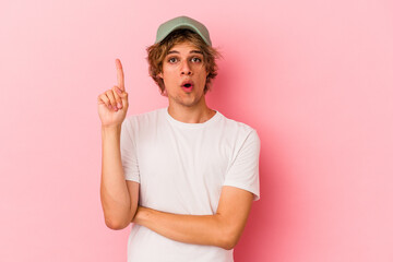 Young caucasian man with make up isolated on pink background having some great idea, concept of creativity.