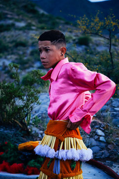 Traditional Mexican dancer getting ready with folk sandals, pink shirt