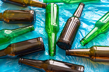 Empty beer or beverage bottles on blue surface. Reuse and recycling of glass. Waste.
