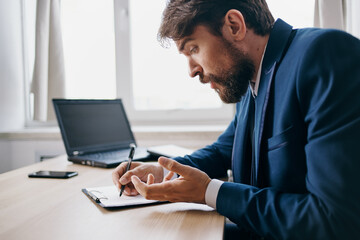 bearded man sitting at a desk in front of a laptop finance technologies