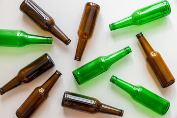 Empty beer or beverage bottles on white surface. Reuse and recycling of glass. Waste.
