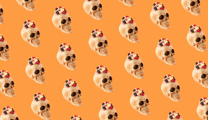 Skull with candies on orange background. Creative Halloween scary concept.