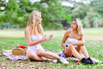 Two women are sitting in the park.