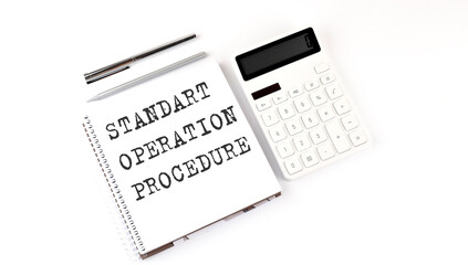 Notepad with text STANDART OPERATION PROCEDURE with calculator and pen. White background. Business concept