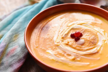 Autumn pumpkin soup on a rough wooden table.