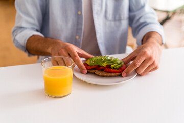Young mixed race man having breakfast in his kitchen