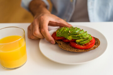 Young mixed race man having breakfast in his kitchen