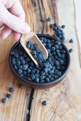 Black chickpeas in a wooden plate on a wooden backround