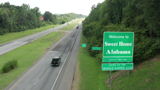 Welcome to Sweet Home Alabama sign along highway. Home of World Games. Dekalb County. Aerial drone view.
