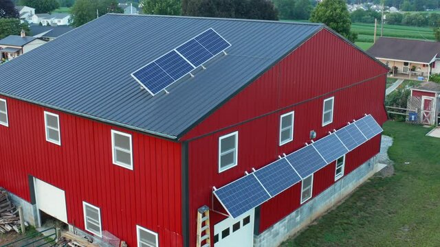 Solar panel arrays for renewable energy on barn in rural America, USA. Aerial view.