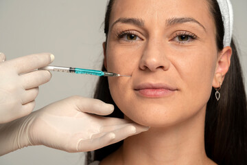 Portrait of a young satisfied woman on a face filler injection procedure