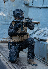 modern soldier in black multicam uniform with rifle, urban background  - 455270536