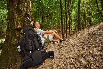 Young man tired during nordic walking in forest