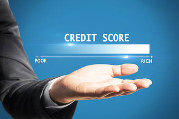 Businessman hand holding credit score scale hologram from poor to rich on blue background. Finance and rating concept.