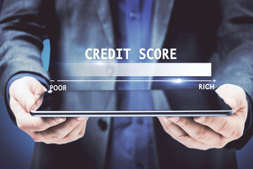 Fototapeta na wymiar Businessman hands holding tablet with glowing credit score hologram on blue background. Finance and rating concept.