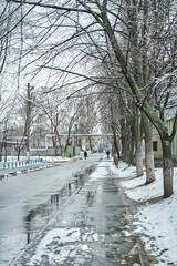 Reflection on the puddle of winter snow covered city scenery