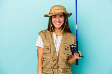Young caucasian fisherwoman isolated on blue background happy, smiling and cheerful.