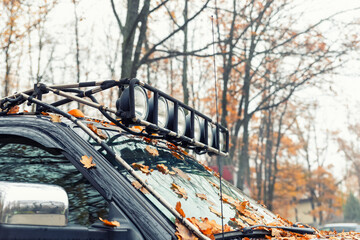 Close-up detail view of custom made roof rack bar with extra headlight mounted on roof of heavy...