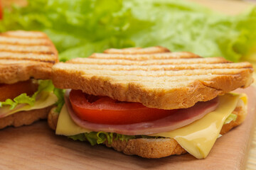 Close-up sandwich with ham cheese and tomato on wooden background