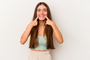 Young caucasian woman isolated on white background smiles, pointing fingers at mouth.