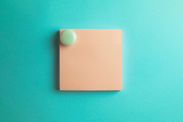 Pink sticky note paper with white circle magnet isolated over blue pastel background.,cliping path...