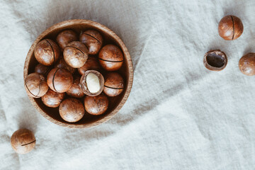 Top view of macadamia nuts in a wooden bowl on a table