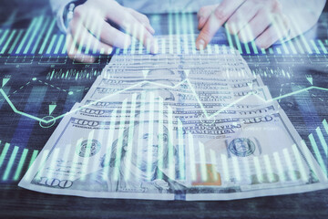 Double exposure of technology drawing hologram and us dollars bills and man hands. Data concept