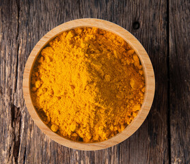 Turmeric powder pile in wood bowl