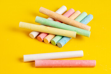 Colorful chalks on yellow background