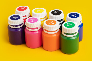 Color oil paint bottles on yellow background