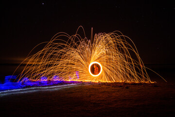 Light-painting photography with fired steel wool. Incandescent steel sparks in long exposure.