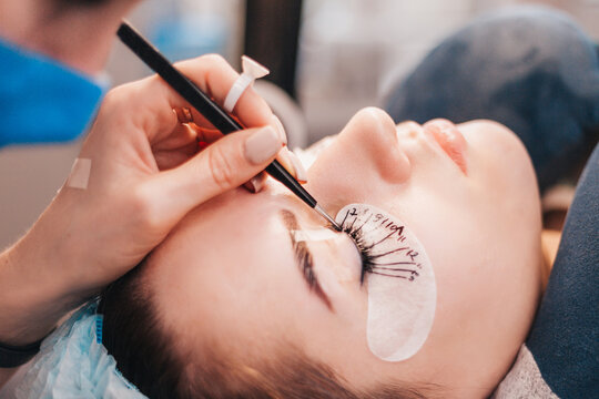 Creation of a unique image of a woman with the help of artificial eyelashes and makeup - in the salon, the master glues beams to the eyelids