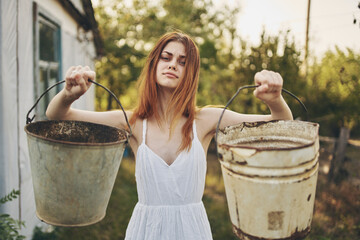 woman in white dress with buckets in hand nature Lifestyle