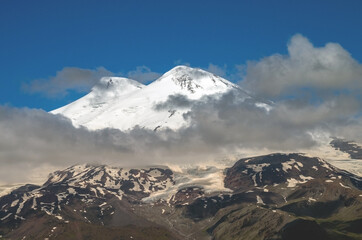 The Caucasian mountain Range. Perspective of caucasian snow mountain or volcano Elbrus. Landscape view - the highest peak of Europe