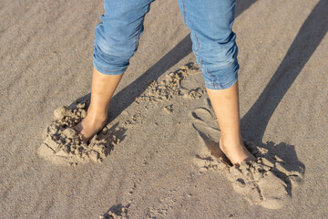 Kid's Bare Feet  Standing  On The Beach At The Sunset