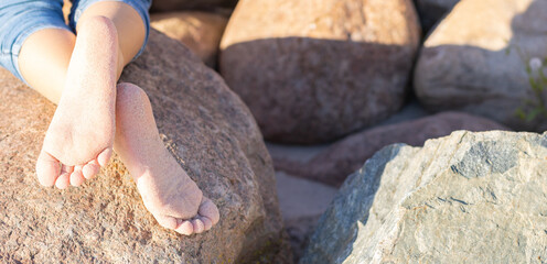 Kid's Bare Feet On Big Rock Near By The Sea.