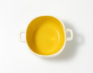empty yellow soup plate on white table, top view