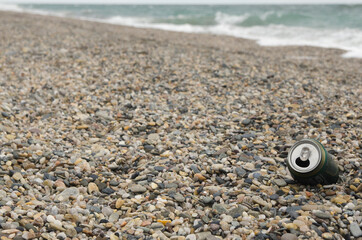 Aluminium can left on sand of beach. Garbage polluting the natural environment and pollution 